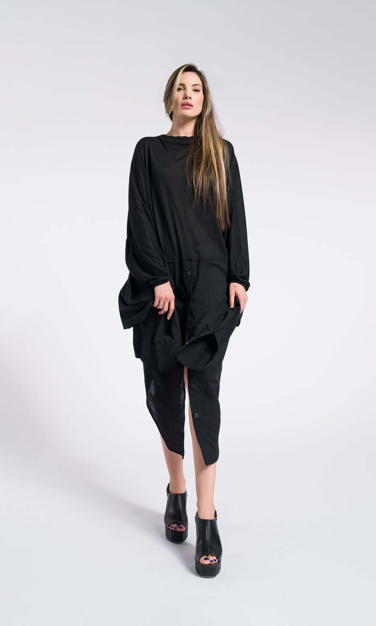 model wearing an oversized, loose-fitting black tunic dress and platform sandals