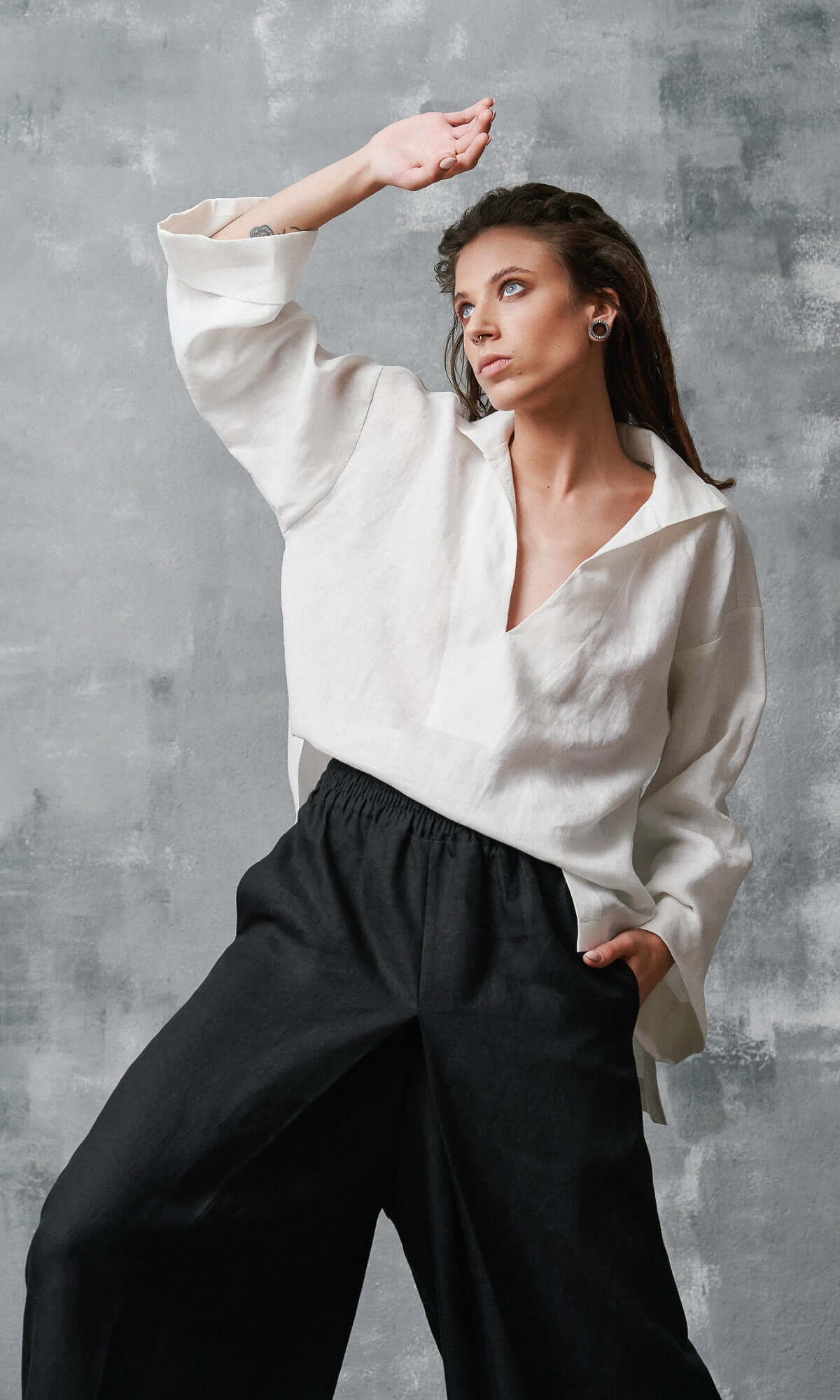Close up of a white linen shirt with deep V-neck and wide collar and elastic waistband black linen wide leg pants