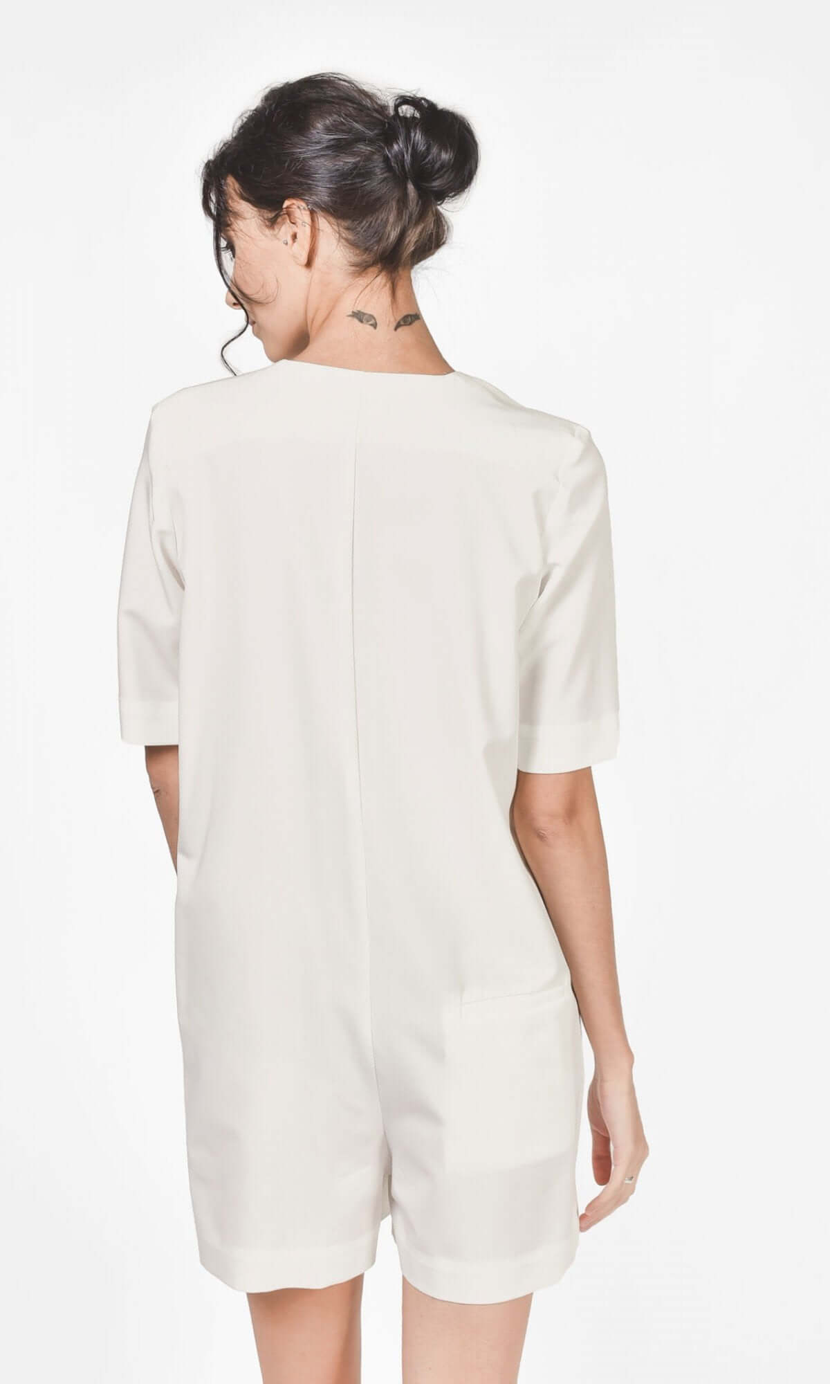 Side view of an off white jumpsuit showing fitted silhouette