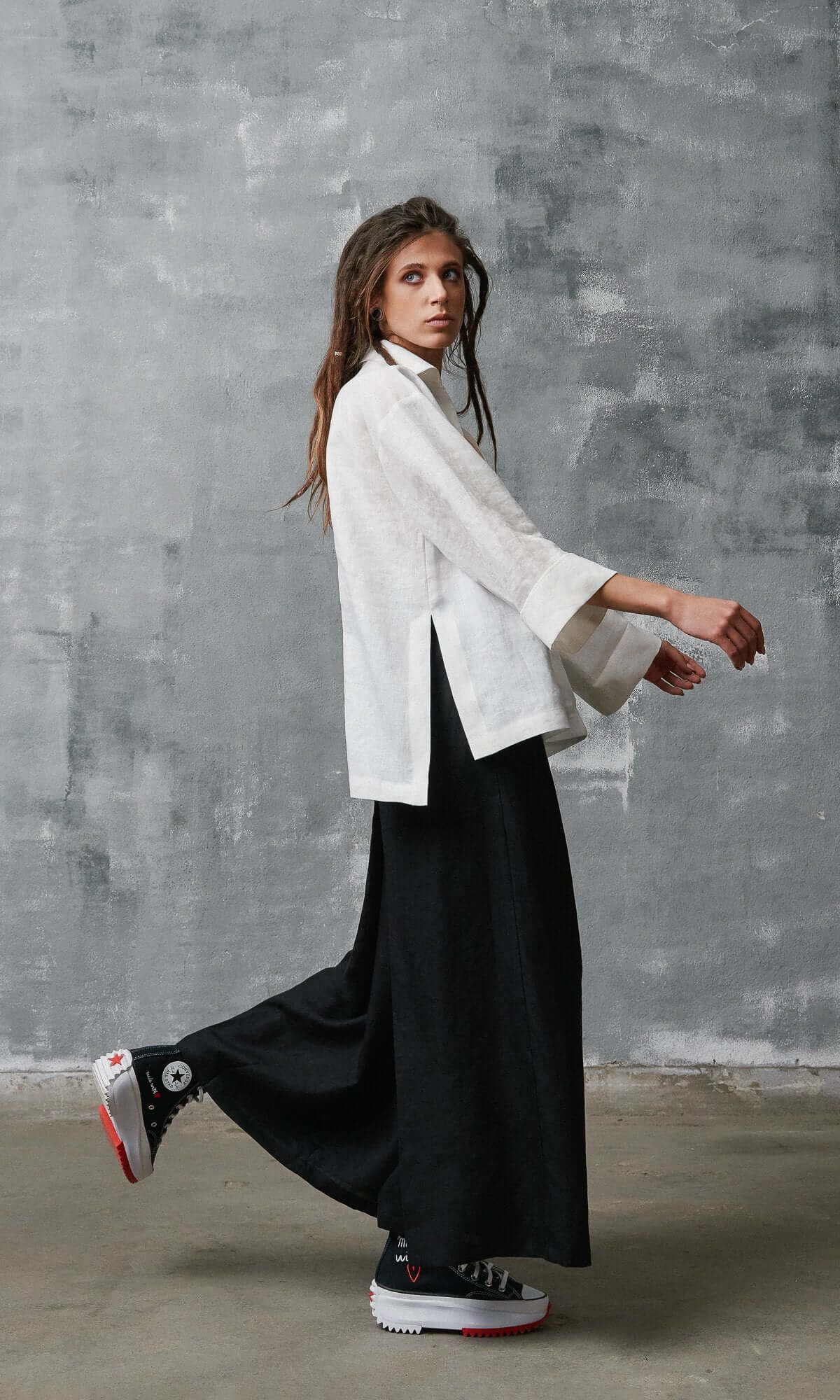 Side view of wide linen shirt with slit and black linen wide lose fit leg pants
