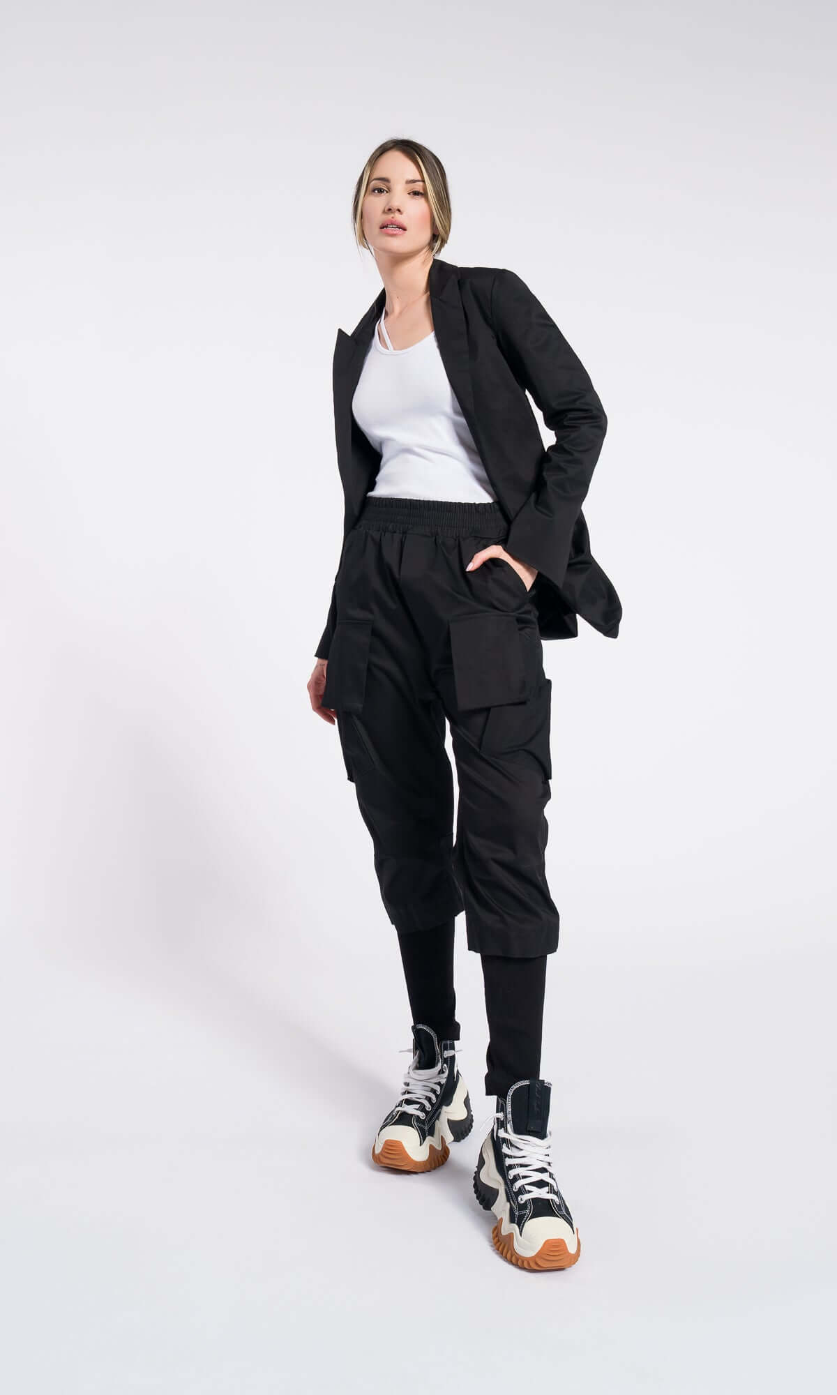 model walking forward in a modern black blazer, white shirt, and black tapered pants