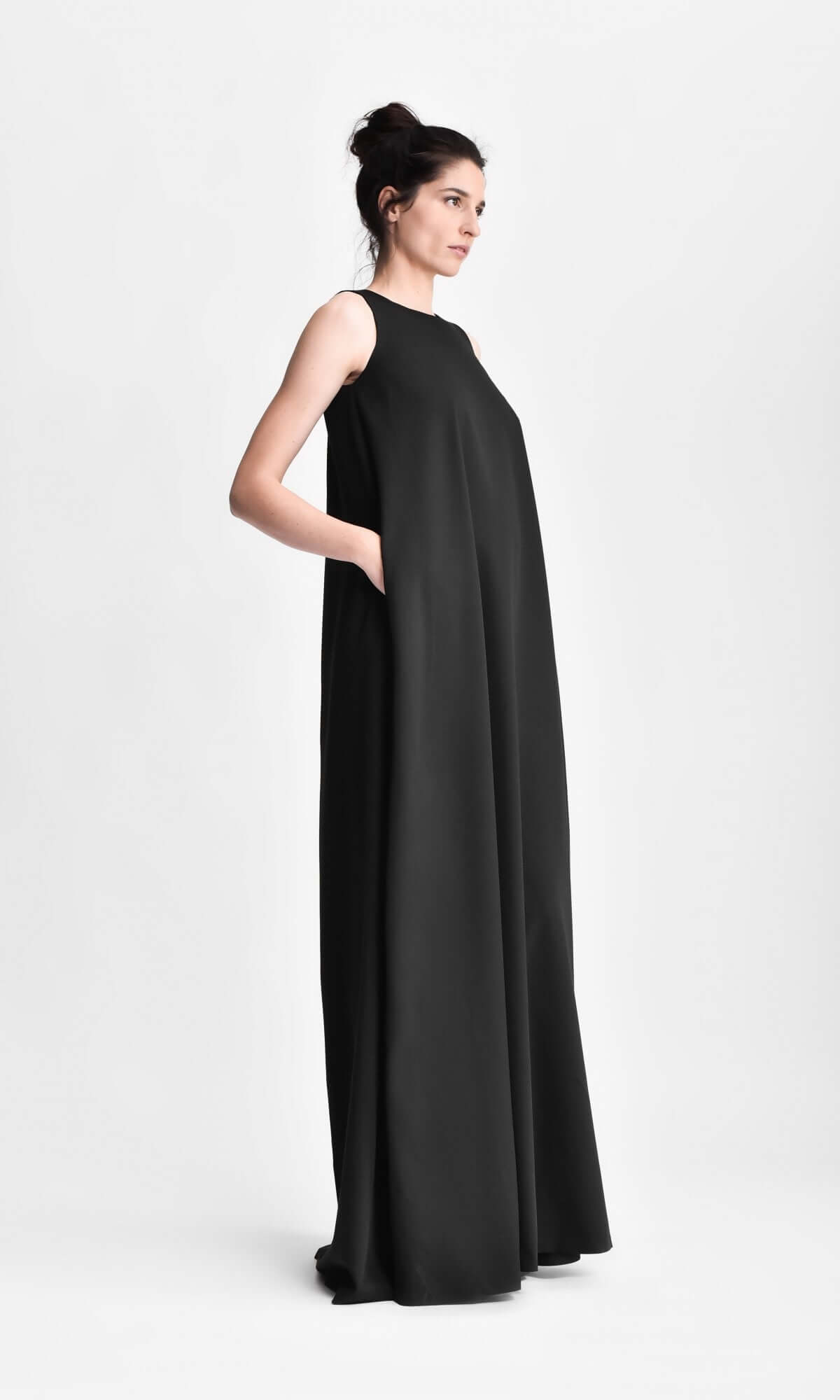 model posing with a hand in the pocket of a flowing black maxi dress