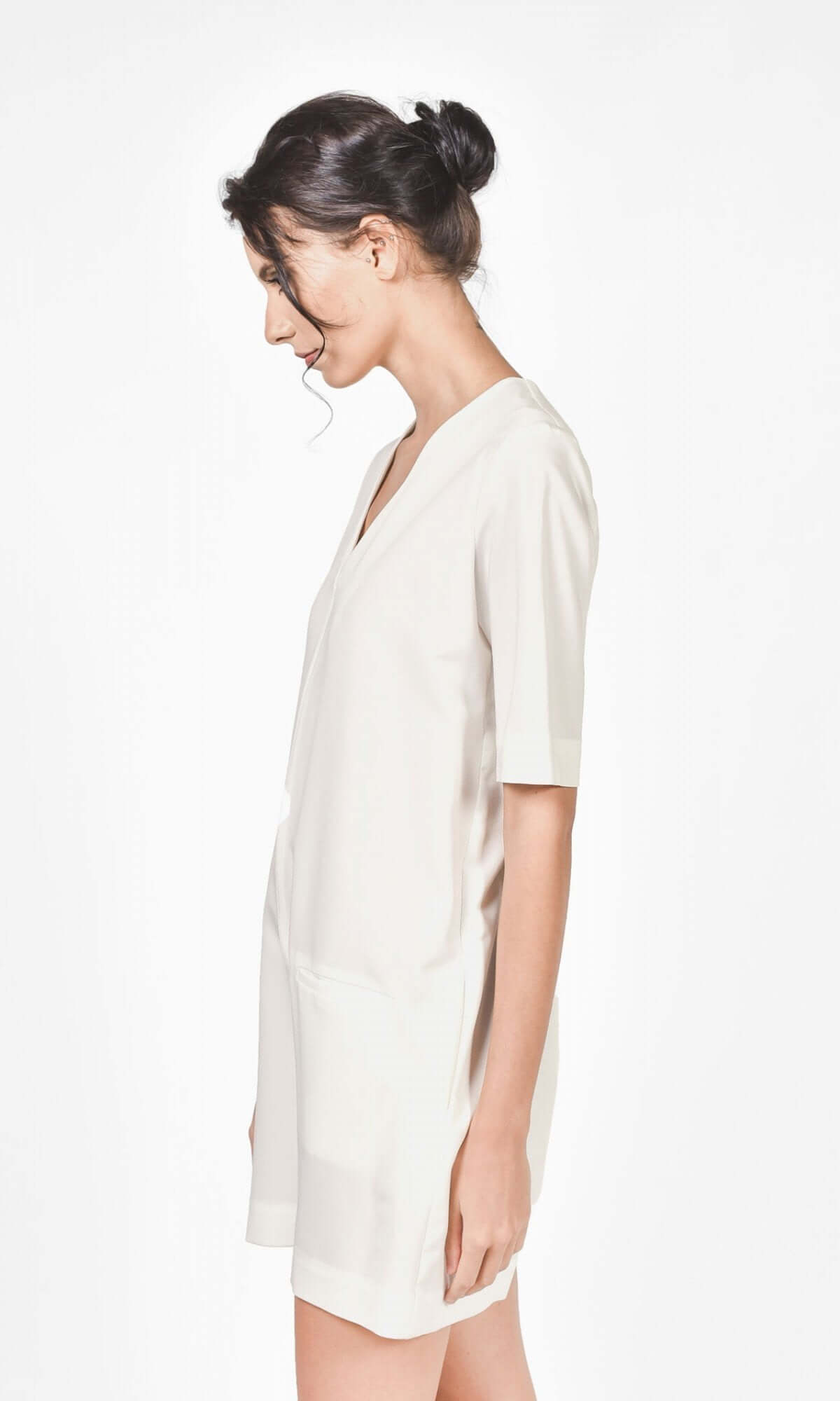 Side view of an off white jumpsuit showing fitted silhouette